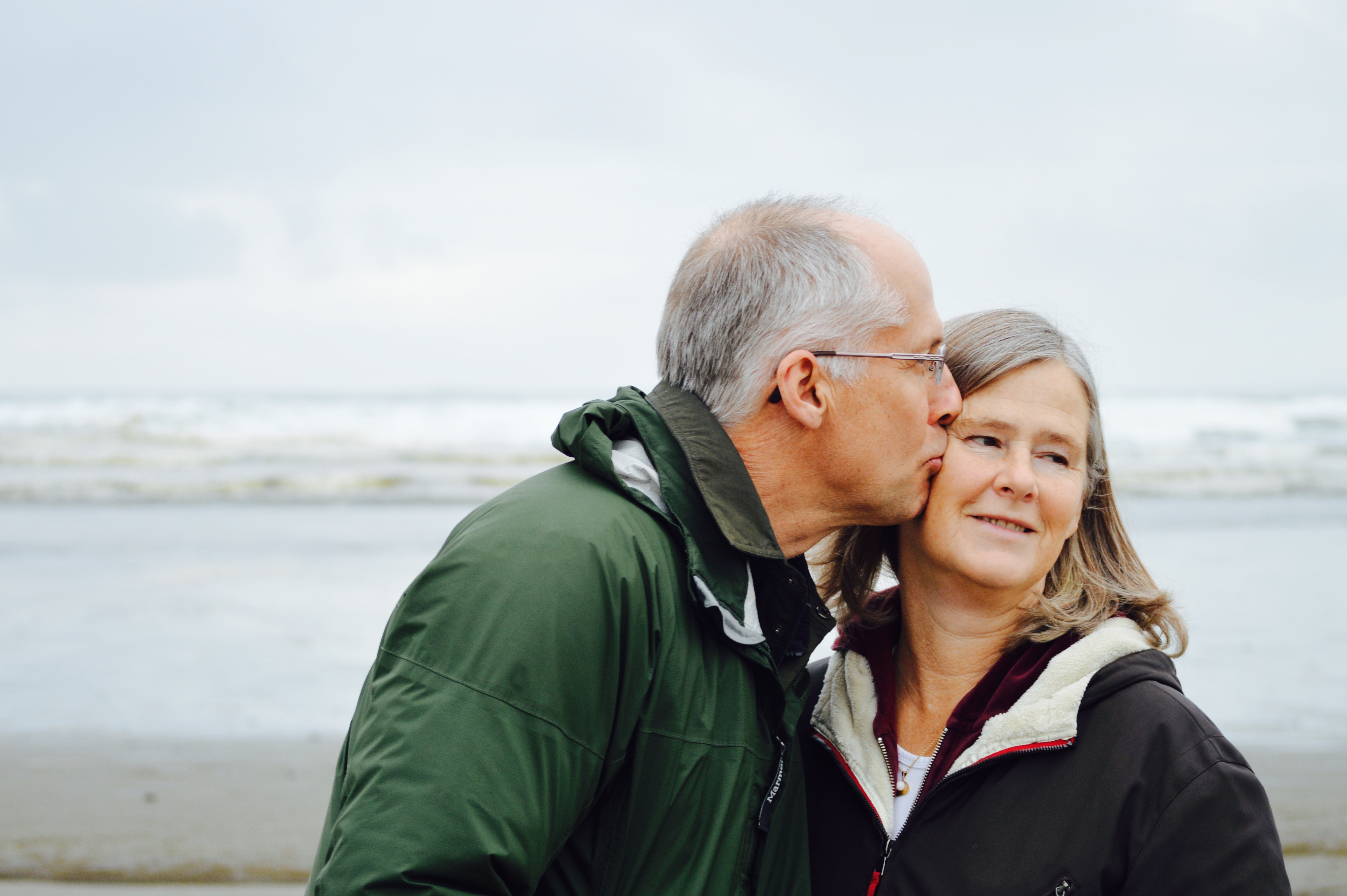 A man kisses his partner on the cheek