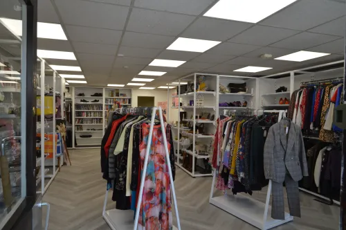 an image of Relate's Evesham charity shop, with an assortment of clothes on the racks.