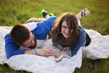 Young man and woman cuddling on a blanket